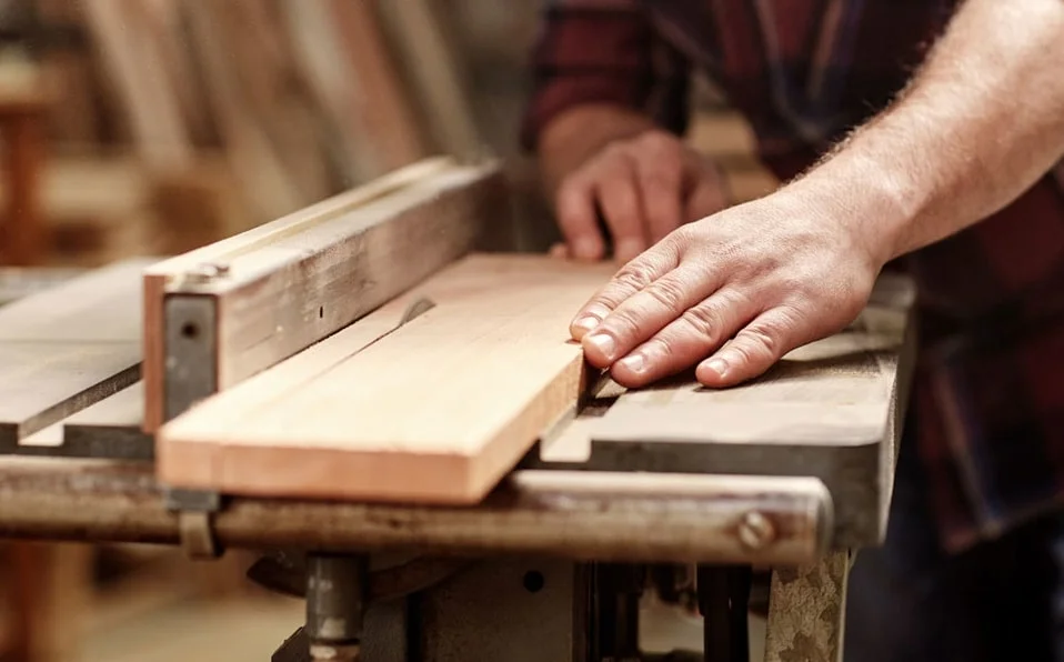 a person using a machine to cut a piece of wood, The Original WOrkshop